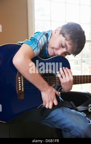 Ragazzo sorridente abbracciando la chitarra Foto Stock