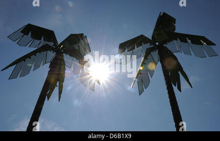 Il sole splende dietro un metallo Palm tree a Park Fiction in Amburgo, Germania, 14 agosto 2012. Foto: Angelika Warmuth Foto Stock