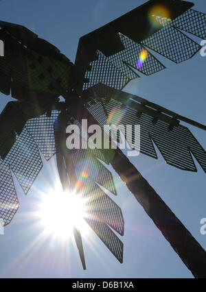 Il sole splende dietro un metallo Palm tree a Park Fiction in Amburgo, Germania, 14 agosto 2012. Foto: Angelika Warmuth Foto Stock