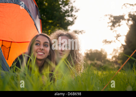 Le ragazze adolescenti che stabilisce in tenda al campeggio Foto Stock