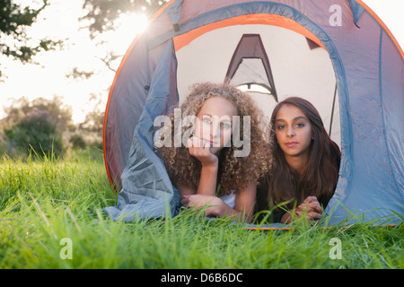 Le ragazze adolescenti che stabilisce in tenda al campeggio Foto Stock