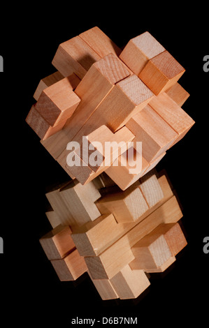 La costruzione di blocchi con immagine speculare formando un impegnativo puzzle isolata su uno sfondo nero Foto Stock