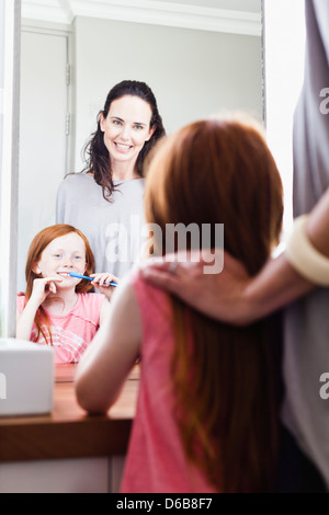 Madre guarda la figlia spazzola denti Foto Stock