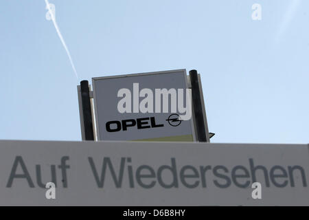 Il logo del costruttore di auto Opel è visto dietro un cartello che recita 'arrivederci' in Ruesselsheim, Germania, 23 agosto 2012. Il costruttore di auto Opel sta attraversando una crisi ed è ora tirando il freno di emergenza: migliaia di dipendenti sarà impostata per breve tempo di lavoro a partire dal mese di settembre. Opel non può più permettersi la costosa capacità in eccesso. Foto: FREDRIK VON ERICHSEN Foto Stock