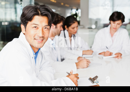 Medico sorridente in riunione Foto Stock
