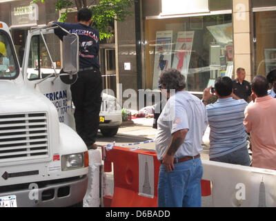 Cavalletto di pedoni e guardare un uomo che è stato girato su una strada vicino all'Empire State Building di New York, NY, STATI UNITI D'AMERICA, 24 agosto 2012. Secondo i resoconti dei mass media, due uomini sono stati uccisi e otto feriti nel corso di una sparatoria di fronte all'Empire State Building di New York. Foto: Mickey Marrero Foto Stock