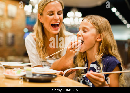 Madre e figlia utilizzando bastoncini Foto Stock