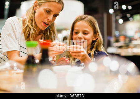 Madre e figlia utilizzando bastoncini Foto Stock