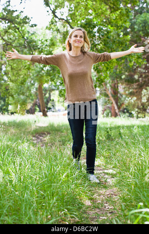 Donna che cammina in posizione di parcheggio Foto Stock