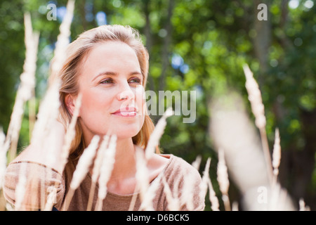 Donna seduta in erba alta Foto Stock