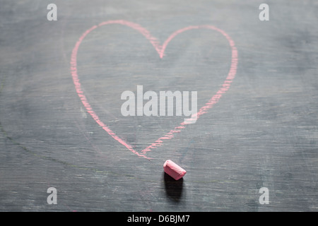 Chalk e forma di cuore sulla lavagna Foto Stock