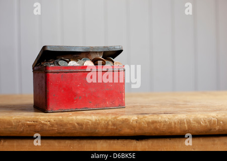 Antico stagno pieno di denaro sulla scrivania Foto Stock