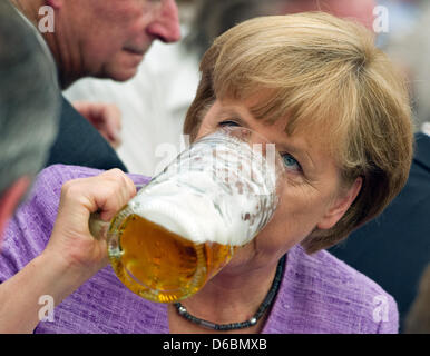 Il cancelliere tedesco Angela Merkel bevande birra durante il politico Gillamoos pinta mattutina in Abensberg, Germania, 03 settembre 2012. Gillamoos è uno dei più grandi e più antiche fiere in Bassa Baviera. Alla fine del periodo di cinque giorni-party, Tedesco politici fanno una fase aspetto al festival tenda e tenere in stile bavarese discorsi politici. Foto: PETER KNEFFEL Foto Stock