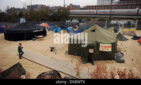 FILE - Un archivio foto datata 15 novembre 2011 mostra un attivista occupano attraversando a piedi il camp a motivi di Bundespressestrand ("federal-stampa-spiaggia') di Berlino, Germania. La Berlin seguaci del movimento occupano devono abbandonare il loro accampamento fino al 06 gennaio 2012, 12am. In caso contrario l'Autorità federale per la proprietà reale somministrazione porterà le accuse contro di loro. Phot Foto Stock