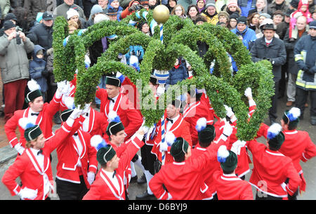 Coopers eseguire le loro danze tradizionali e ricevono il loro ritmo da chi bussa un barile in Dinkelscherben, Germania, 06 gennaio 2012. La complessa danza con ghirlande e abiti tradizionali viene eseguito ogni sette anni e dura fino al Martedì Grasso. Foto:Stefan Puchner Foto Stock