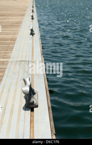 Dettaglio del legno di un bacino galleggiante con bitte di ormeggio Foto Stock