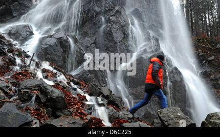 Un uomo cammina davanti a una cascata a valle Radau nella regione di Harz nei pressi di Bad Harzburg, Germania, 09 gennaio 2012. Il meteo nella regione di Harz si alterna tra winterlike temperature e lo scongelamento. Foto: Julian Stratenschulte Foto Stock