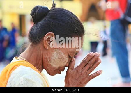 Una donna che prega con le mani alla Shwedagon pagoda in Yangon, Myanmar, 5 febbraio 2013. Foto Stock
