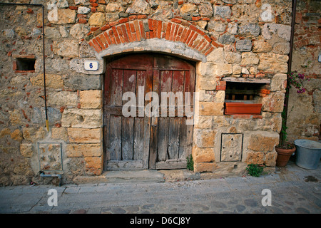 Vecchia porta di legno in una casa di pietra in Monteriggioni Toscana Italia Foto Stock