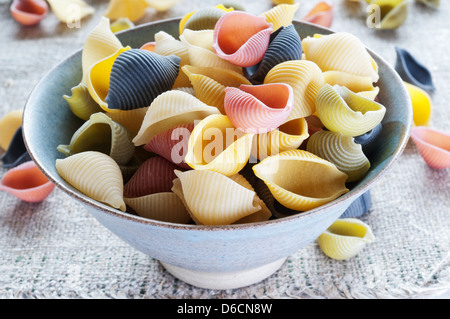 Colorato la pasta nella ciotola sul panno grossolano Foto Stock