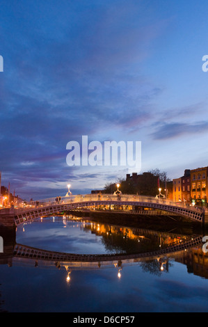Vista verticale di Ha'penny Bridge aka Droichead na Leathphingine o Liffey bridge a Dublino al tramonto. Foto Stock