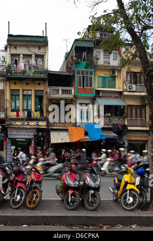 Vista verticale di lotti di ciclomotori, il favorito di una forma di trasporto in Vietnam parcheggiata sul lato della strada. Foto Stock