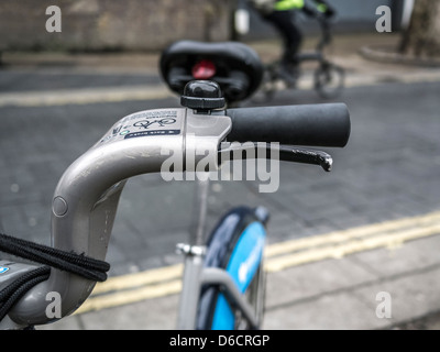 Primo piano delle barre di manovra di una Boris Bike parcheggiata con il pendurter fuori fuoco su una push bike in background passato, preso il 24th gennaio 2013 Foto Stock