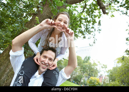 Ragazza seduta sul ragazzo spalle in posizione di parcheggio Foto Stock