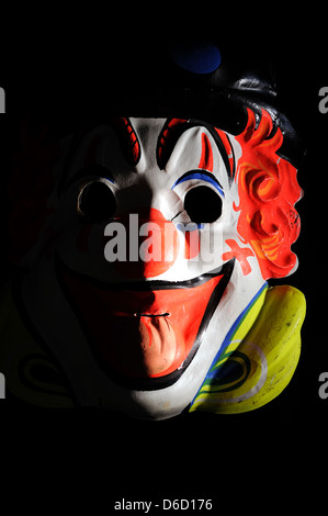 Maschera di clown nascondere qualcosa di minaccioso. Foto Stock