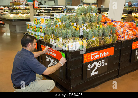 Sterling Heights, Michigan - un lavoratore sostituisce segni nel produrre la sezione sezione di un Walmart store. Foto Stock