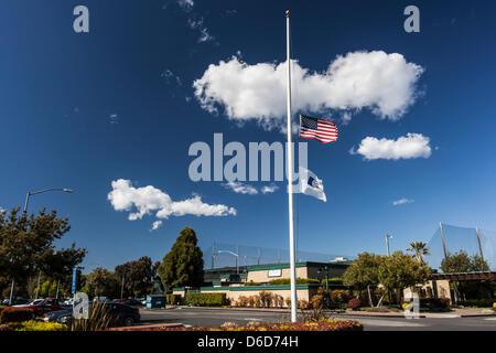 La bandiera americana e American Golf bandiera volare a metà il montante esterno del Tony Lema Campo da Golf, un corso comunale di San Leandro, California, oltre tremila miglia da Boston, Massachusetts, e Boston Marathon bombardamenti. Foto Stock