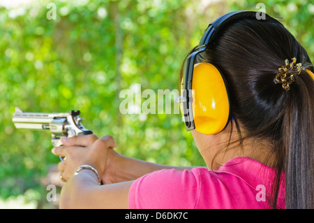 Asian giovane donna tiro con un toro 357 revolver Magnum su un poligono di tiro - Puerto Galera, Filippine, Sud-est asiatico Foto Stock