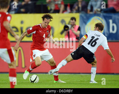 Dell'Austria Emanuel Pogatetz (L) il sistema VIES per la palla con la Germania Philipp Lahm durante il Gruppo C di Coppa del Mondo 2014 partita di qualificazione tra Austria e Germania a Ernst-Happel stadium di Vienna (Austria), 11 settembre 2012. Foto: Peter Steffen dpa +++(c) dpa - Bildfunk+++ Foto Stock