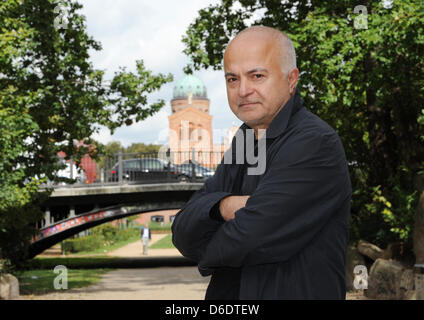 Dpa-esclusivo: l'artista e architetto Yadegar Asisi sorge sul ponte sul Waldemarstraße con il Sankt-Michael-Kirche (chiesa di Saint Michael) in background nei pressi del Engelbecken nel quartiere Kreuzberg di Berlino, Germania, 12 settembre 2012. Il punto di vista della chiesa è stata bloccata dal muro di Berlino, che correva lungo la piazza e nel 1986 Asisi dipinto una fictiona Foto Stock