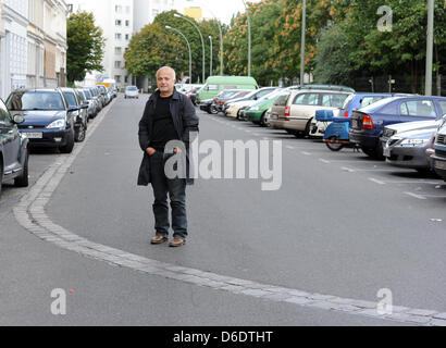 Dpa-esclusivo: l'artista e architetto Yadegar Asisi sorge all'angolo di Sebastian-Straße am Alfred-Doeblin-Platz nel quartiere Kreuzberg di Berlino, Germania, 12 settembre 2012. L'angolo di strada con la linea di ciottoli, che segna il corso del vecchio Muro di Berlino, costituisce la vera vita di base visiva del suo ultimo progetto, il muro di Berlino. Il creatore del BER Foto Stock