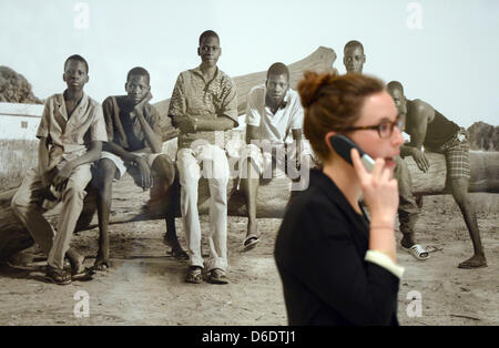 Una donna parla al telefono come lei cammina in passato una fotografia alla fiera "Albert Watson - Visioni feat. Realizzato in cotone in Africa' di opere del fotografo scozzese Albert Watson presso la Casa della fotografia di Amburgo, Germania, 13 settembre 2012. Più di 350 presenta sono in mostra fino al 06 gennaio 2013. Foto: MARCUS BRANDT Foto Stock