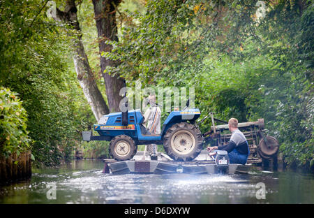 Il trasporto dei lavoratori di un trattore in due barche su un su annulla vicino a Luebbenau, Germania, 15 settembre 2012. Nella regione Spreewald, di persone e merci varie sono tradizionalmente trasportati da barche. Foto: Kay Nietfeld Foto Stock