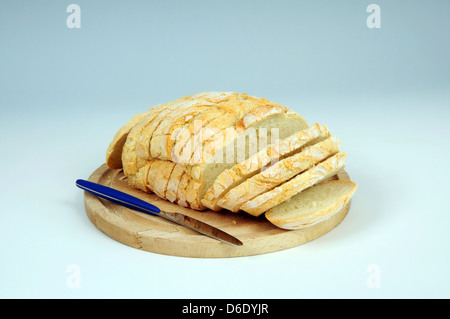 Appena sfornato il pane bianco tagliato a fette su un tagliere di legno. Foto Stock