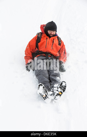 Un viandante bum scorre giù massiccia neve si sposta bloccando il Kirkstone pass road al di sopra di Ambleside Foto Stock