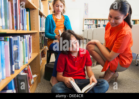 Studenti e docenti la lettura in biblioteca Foto Stock