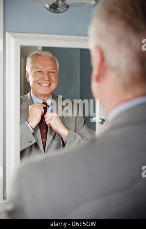 Imprenditore adegua la sua cravatta in specchio Foto Stock