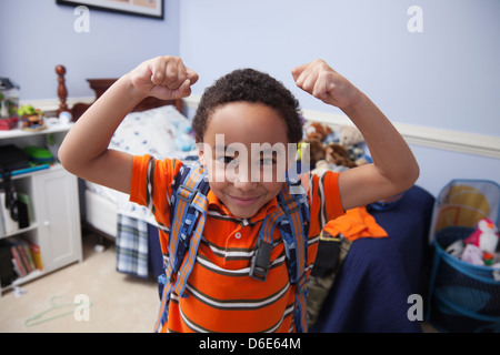 Razza mista ragazzo indossa uno zaino in camera da letto Foto Stock