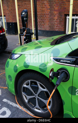 Una Vauxhall Ampera zipcar collegato a un punto di carica e ricarica in Camden. Foto Stock