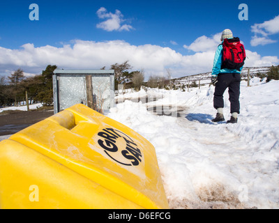 Una donna che camminano su una corsia nevoso vicino al Stiperstones, Shropshire, Regno Unito. Foto Stock