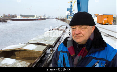 Inland sailor Reinhard Weiss sorge nel porto congelate di Madgeburg, Germania, 07 febbraio 2012. Il 56 anno vecchio da Hohenwarthe non riesce a far funzionare i suoi due towboats sul suo percorso tra Amburgo e Berlino a causa della persistente temperature gelide. Foto: Jens WOLF Foto Stock