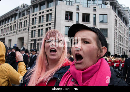 London, England Regno Unito 17/04/2013. I manifestanti in piedi alla Ludgate Circus gira le spalle alla processione militari e per il canto "spreco di denaro" come parte di una protesta contro onorando ex primo ministro del Regno Unito Margaret Thatcher con un cerimoniale di funerale. Foto Stock