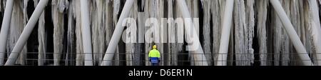 Un dipendente della società elettrica Vattenfall sorge di fronte alla torre di raffreddamento di una stazione di generazione in Reuter-West a Berlino, Germania, 09 febbraio 2012. Alcuni dei ghiaccioli sono sette metri di lunghezza, a causa del gelo permanente. Foto: Annibale Foto Stock