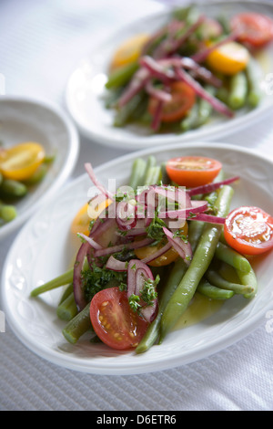 Con insalata di pomodori, Francese fagiolini, cipolla rossa e olio. Foto Stock