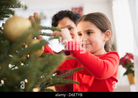 Madre e figlia decorare albero di Natale Foto Stock