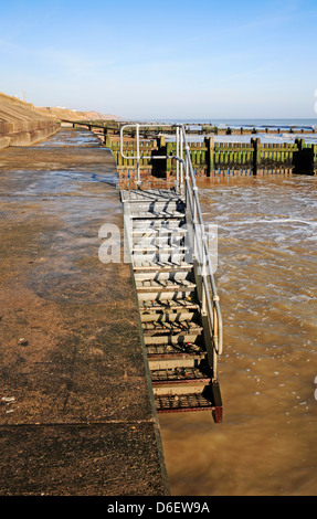 Un esempio di grave beach purga lasciando i gradini di accesso sospeso a Bacton-on-Sea, Norfolk, Inghilterra, Regno Unito. Foto Stock